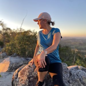 Woman sitting on top of Mt Cooroora at sunrise